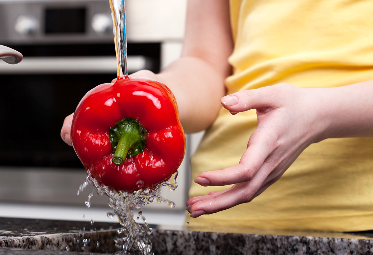 Απεικονίζεται ένα γυναικείο χέρι που κρατάει μία πιπεριά.
